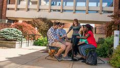 Seven students gathered around a table socializing